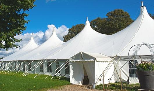 tall green portable restrooms assembled at a music festival, contributing to an organized and sanitary environment for guests in Lyman